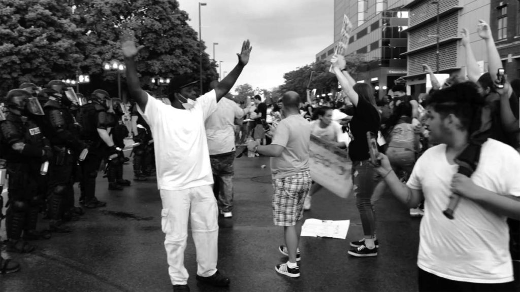 Black and white image of people protesting in the streets