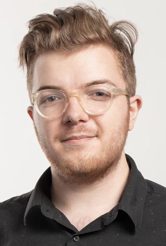 Dalton Tokarczyk wearing reading-glasses and a black shirt